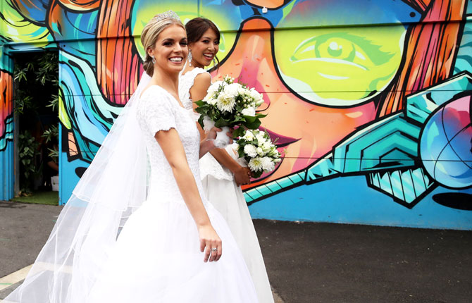 Two women in bridal gowns walk around Garden Square at Melbourne Park on Friday, January 18