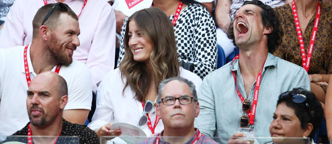 Australian cricketer Aaron Finch, comedian Andy Lee and model Rebecca Harding share a laugh during  the men's singles semi-final between Rafael Nadal and Stefanos Tsitsipas on Thursday