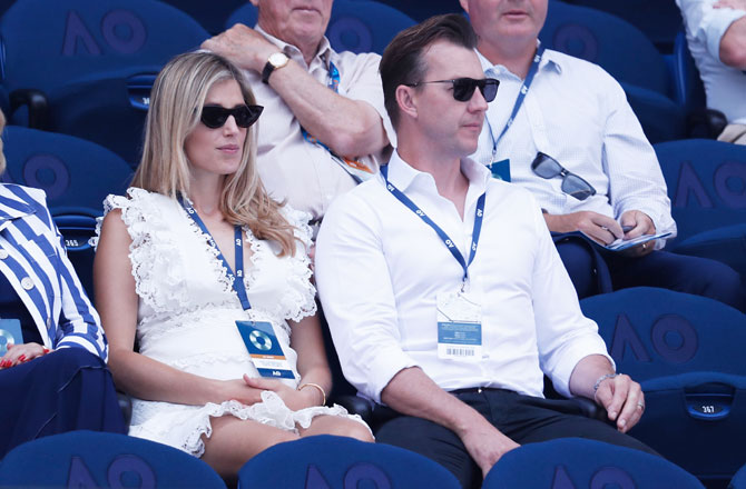 Former Australian cricketer Brett Lee and a friend watch the quarter-final match between Stefanos Tsitsipas and Roberto Bautista Agut on Tuesday