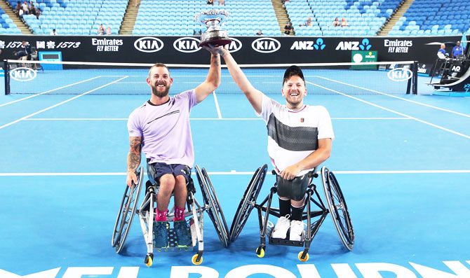 Australia’s Dylan Alcott and Heath Davidson raise the cup after winning their Quad Wheelchair doubles final against Andy Lapthorne of Great Britain and David Wagner of the United States on Thursday, January 24
