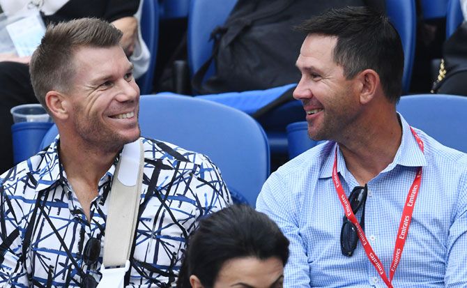 Banned Australian cricketer David Warner and former Australian cricket captain Ricky Ponting chat before the men's semi-final between Serbia's Novak Djokovic and France's Lucas Pouille on Friday
