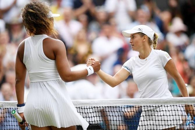 Kazakhstan's Yulia Putintseva and Japan's Naomi Osaka shake hands at the net after their first round match at Wimbledon.