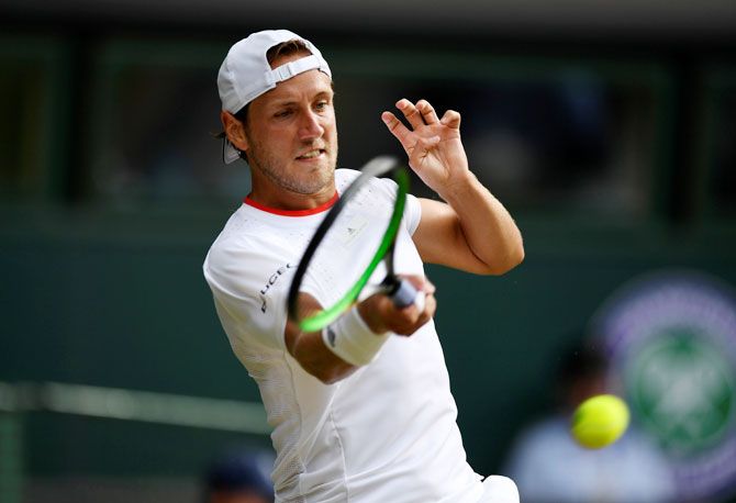 France's Lucas Pouille returns during his third round match against Switzerland's Roger Federer