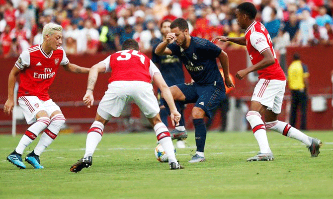 Real Madrid's new recruit Eden Hazard is challenged by Arsenal players during their International Champions Cup match on Tuesday