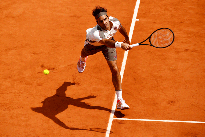 Roger Federer stretches to play a backhand during his men's singles semi-final match against Rafael Nadal