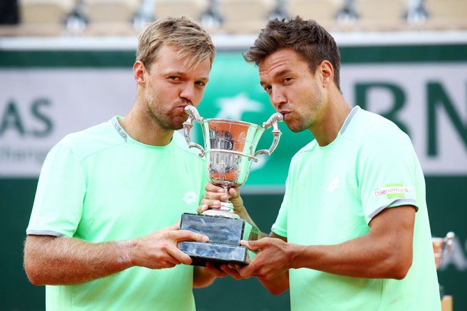 Germany's Kevin Krawietz and Andreas Mies kiss the trophy as they celebrate winning the French Open men's doubles final against France's Jeremy Chardy Fabrice Martin at Roland Garros on Saturday
