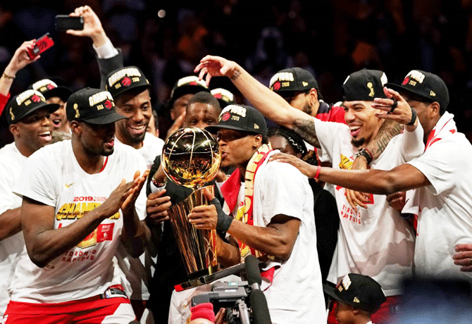 Toronto Raptors players kiss the Larry O'Brien Trophy after beating the Golden State Warriors to win the 2019 NBA Finals at Oracle Arena in Oakland, California on Thursday