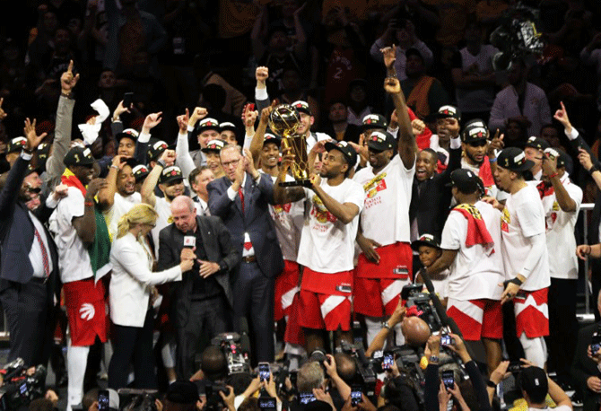 Toronto Raptors forward Kawhi Leonard (2) lifts up the Larry O'Brien Championship Trophy after beating Golden State Warriors to win the NBA Championship in game six of the 2019 NBA Finals at Oracle Arena in Oakland, California, on Thursday, June 13