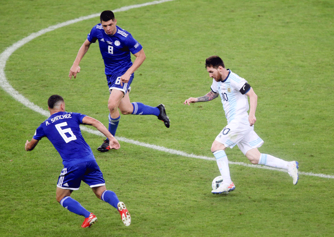 Argentina's Lionel Messi runs past Paraguay's Richard Sanchez and Rodrigo Rojas during their Copa America Group B match at Mineirao Stadium, Belo Horizonte on Wednesday