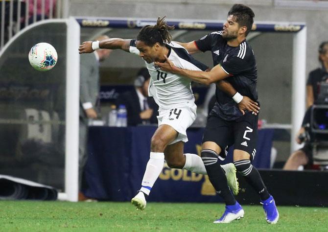 Costa Rica forward Jonathan Mc Donald (14) is grabbed by Mexico defender Nestor Araujo (2) as they vie for possession in the second half of the quarter-final in the CONCACAF Gold Cup soccer tournament at NRG Stadium in Houston, Texas on Saturday