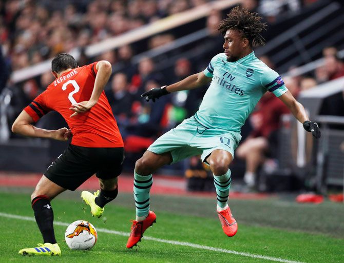 Arsenal's Alex Iwobi and Stade Rennes' Mehdi Zeffane vie for possession during their Europa League Round of 16 First Leg match at Stade Rennes in Roazhon Park, Rennes, France