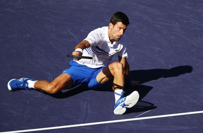 Serbia's Novak Djokovic falls to the court during his straight sets defeat against Germany's Philipp Kohlschreiber during their men's singles third round match on Tuesday, March 12