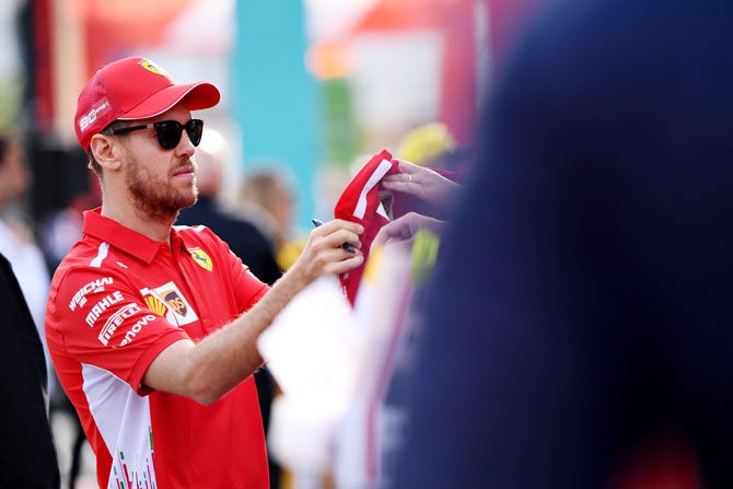 Ferrari's German driver Sebastian Vettel signs autographs for fans at the F1 Live event during previews ahead of the F1 Grand Prix of Australia at Melbourne Grand Prix Circuit in Melbourne on Wednesday