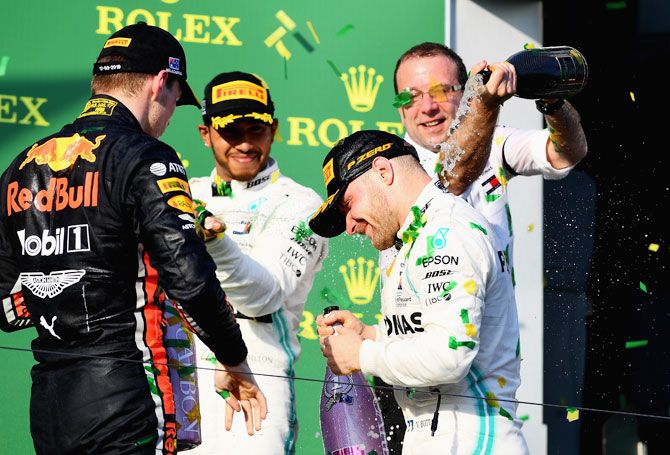 Race winner Valtteri Bottas celebrates on the podium with teammate and second-placed Lewis Hamilton and third-placed Max Verstappen of Red Bull Racing on Sunday