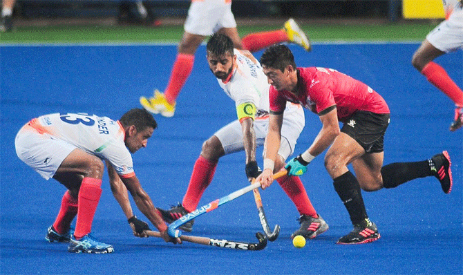 India's hockey players try to intercept a Korean player  during their Sultan Azlan Shah Cup hockey tournament in Ipoh, Malaysia, on Sunday