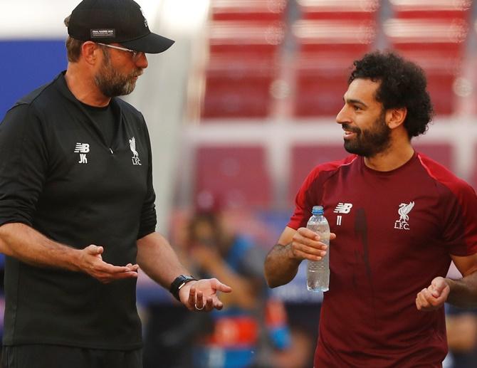 Liverpool manager Juergen Klopp talks with Mohamed Salah during training