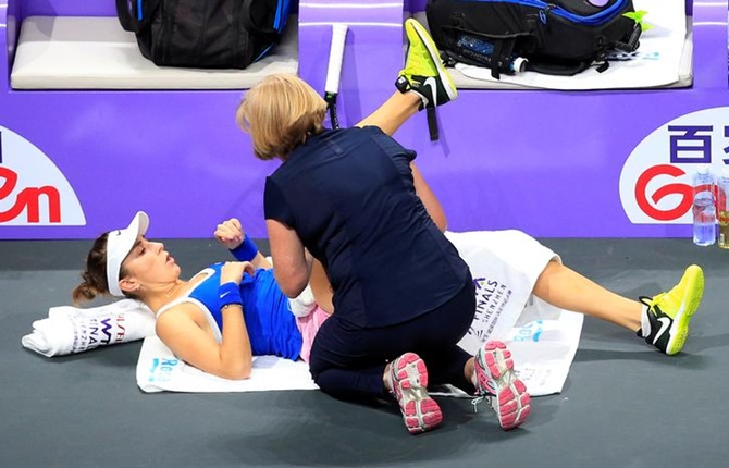 Switzerland's Belinda Bencic receives medical attention during her semi-final against Ukraine's Elina Svitolina.