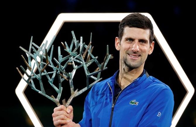Serbia's Novak Djokovic celebrates with the trophy after defeating Canada's Denis Shapovalov and winning the Paris Masters.