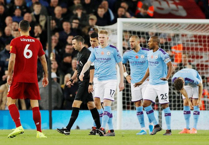 Manchester City's Fernandinho and Kyle Walker remonstrate with referee Michael Oliver as Kevin De Bruyne looks on after Liverpool's Fabinho scores their first goal. The goal was checked by VAR and allowed to stand as Liverpool went on to clinch the victory and move nine points clear of City in the Premier League title race