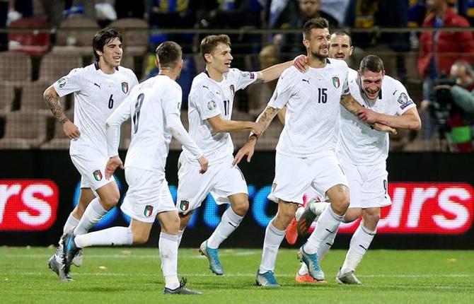 Francesco Acerbi celebrates scoring Italy's first goal with Andrea Belotti and teammates.