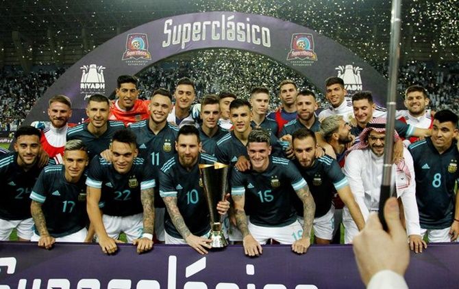 Lionel Messi poses with the trophy along with his Argentina teammates as they celebrate beating Brazil in the Superclasico international friendly