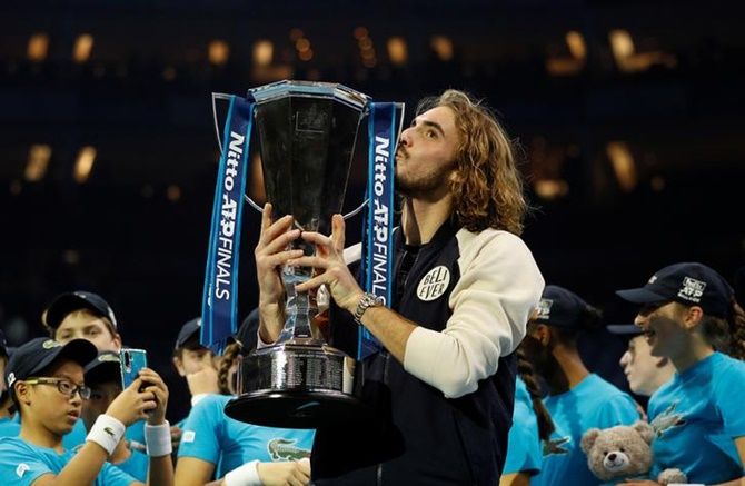 Stefanos Tsitsipas celebrates with the ATP Finals champion's trophy.