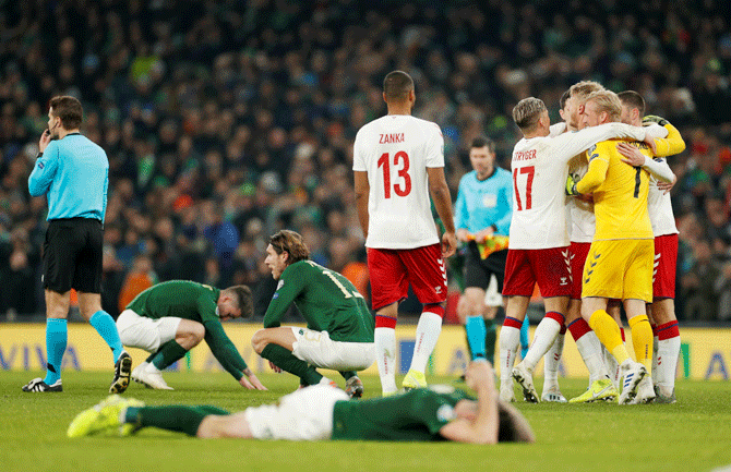 Denmark's Kasper Schmeichel celebrates with teammates as Republic of Ireland players look dejected at the end of their Euro 2020 Qualifier Group D match Action at Aviva Stadium in Dublin, Ireland