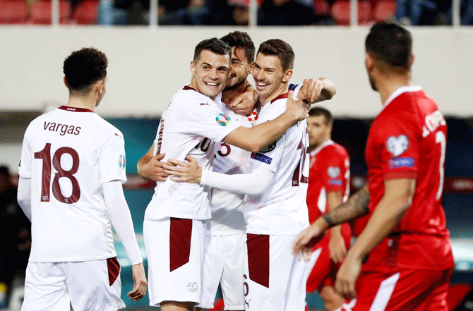 Switzerland's Loris Benito celebrates with Granit Xhaka and teammates after scoring their fourth goal against Gibraltar in their Euro 2020 Qualifier Group D match at Victoria Stadium in Gibraltar on Monday