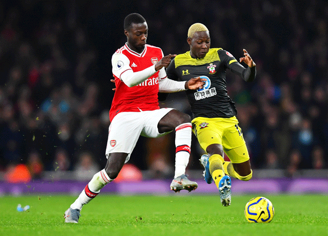 Arsenal's Nicolas Pepe and Southampton's Moussa Djenepo vie for possession