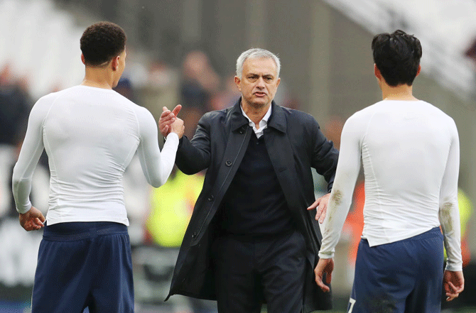 Tottenham Hotspur manager Jose Mourinho embraces Dele Alli and Heung-Min Son after their English Premier League win over West Ham United at London Stadium in London on Saturday