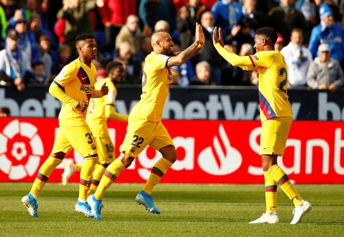 Barcelona's Arturo Vidal celebrates with teammmates after scoring their second goal against Leganes at Estadio Municipal de Butarque in Leganes on Saturday