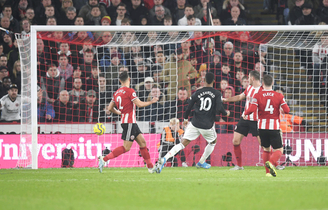 Manchester United's Marcus Rashford scores the third goal against Sheffield United