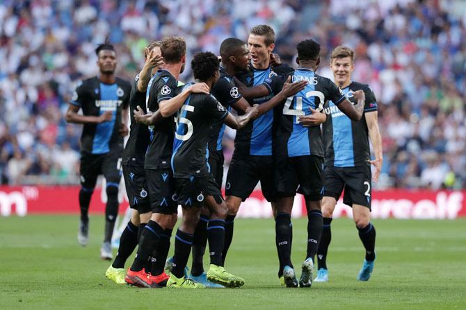 Club Brugge's Emmanuel Bonaventure Dennis celebrates with teammates after scoring his team's first goal against Real Madrid during their UEFA Champions League Group A match at Santiago Bernabeu in Madrid on Tuesday