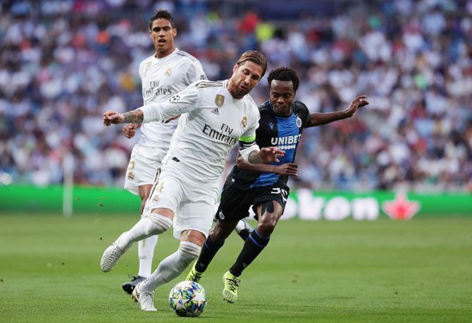 Club Brugge's Percy Tau battles for possession with Real Madrid's Sergio Ramos