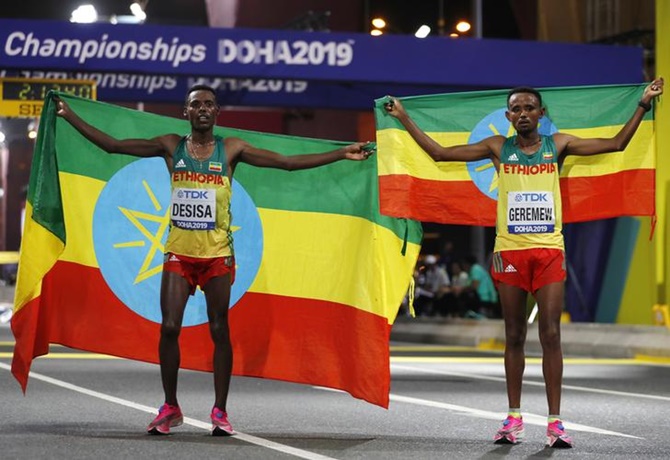 Ethiopia's Lelisa Desisa poses with countryman Mosinet Geremew as he celebrates winning gold after a 1-2 finish in the men's marathon at the World Athletics Championships, in Doha, on Sunday.