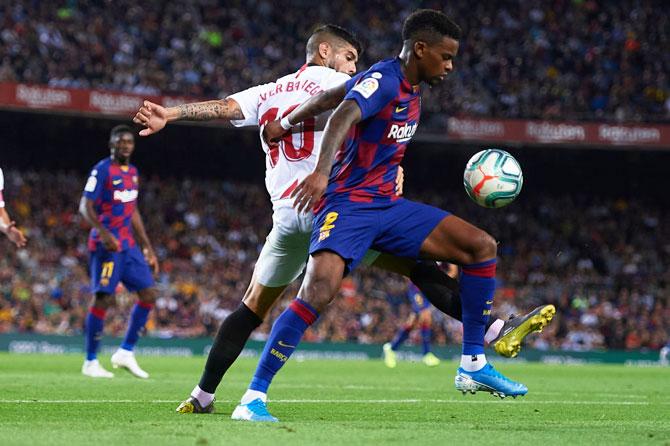 Sevilla FC's Ever Banega (L) competes for the ball with FC Barcelona's Nelson Semedo 