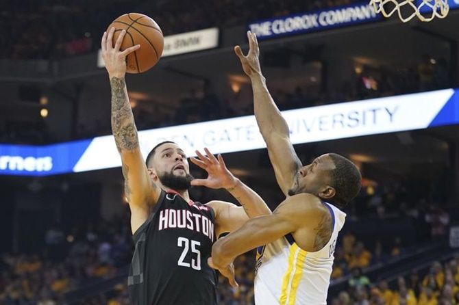 Houston Rockets guard Austin Rivers (25) tries to score against Golden State Warriors guard Andre Iguodala (9) during the 2019 NBA Playoffs at Oracle Arena.