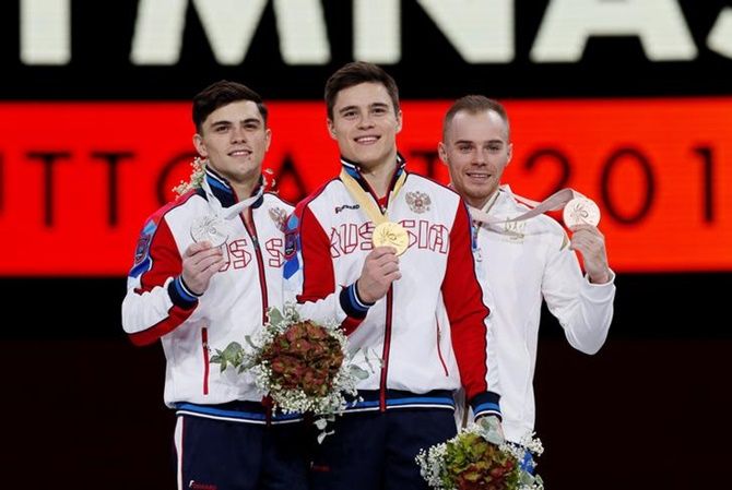 Gold medalist Russia's Nikita Nagornyy, silver medalist Russia's Artur Dalaloyan and bronze medalist Ukraine's Oleg Verniaiev celebrate on the podium