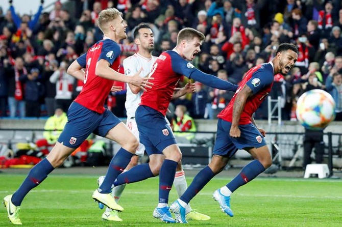 Kristoffer Ajer, Alexander Soerloth and Joshua King celebrate after the latter scores in stoppage time toclinch a draw with Spain.