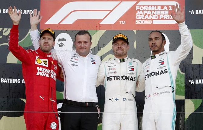  Mercedes's Valtteri Bottas celebrates winning the Japanese Grand Prix alongside second-placed Ferrari's Sebastian Vettel and third-placed Mercedes's Lewis Hamilton.