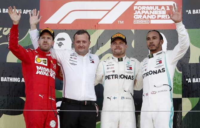  Mercedes's Valtteri Bottas celebrates winning the Japanese Grand Prix alongside second-placed Ferrari's Sebastian Vettel and third-placed Mercedes's Lewis Hamilton.