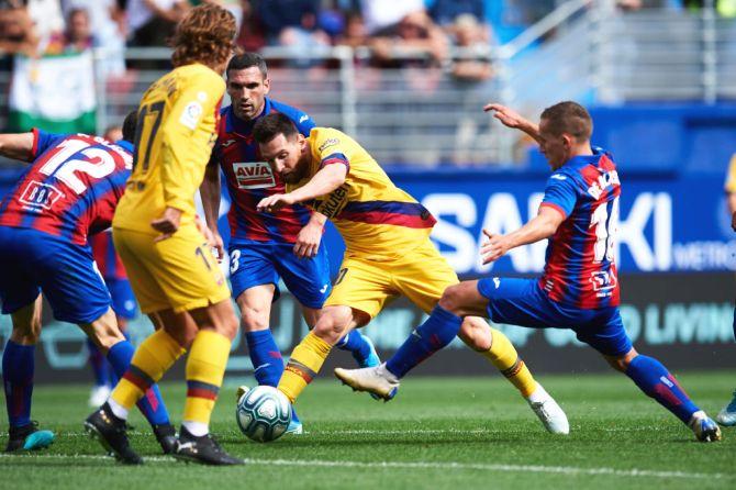 Lionel Messi (centre) competes for the ball with SD Eibar players