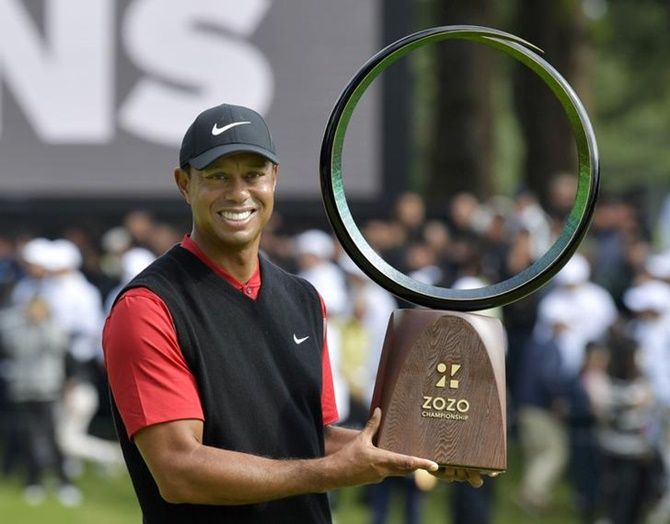 Tiger Woods holds the winning trophy as he celebrates winning the Zozo Championship