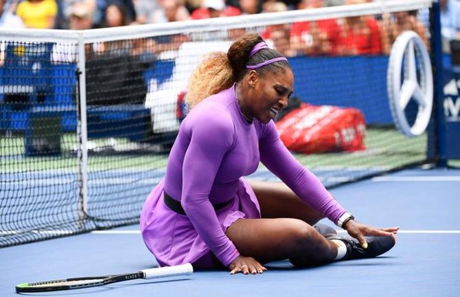 Serena Williams reacts after a fall at the net during her match against Petra Martic.