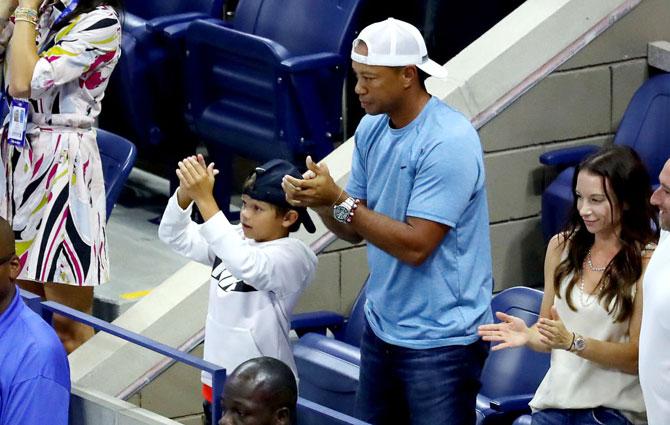 Golfer Tiger Woods applauds Serena Williams after her win over Wang Qiang