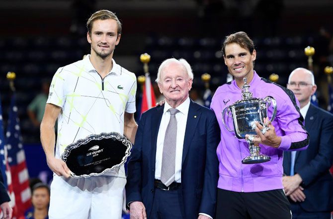 Rafael Nadal of Spain (right) and Daniil Medvedev of Russia (left) hold their trophies while posing with Rod Laver after the US Open final on Sunday