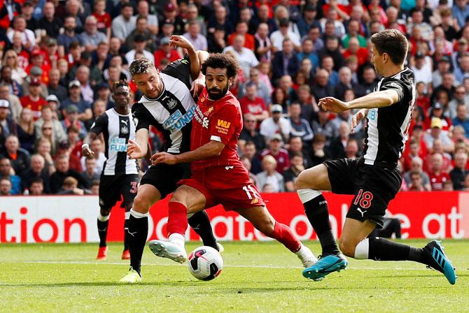 Liverpool's Mohamed Salah and Newcastle United's Paul Dummett and Federico Fernandez vie for possession