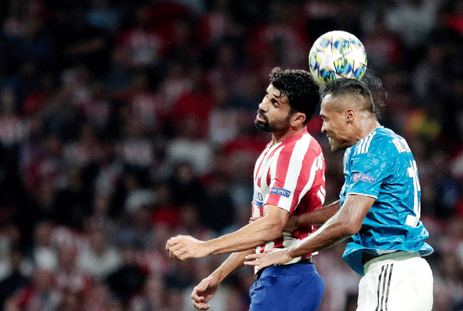 Atletico Madrid's Diego Costa in an aerial challenge with Juventus' Alex Sandro
