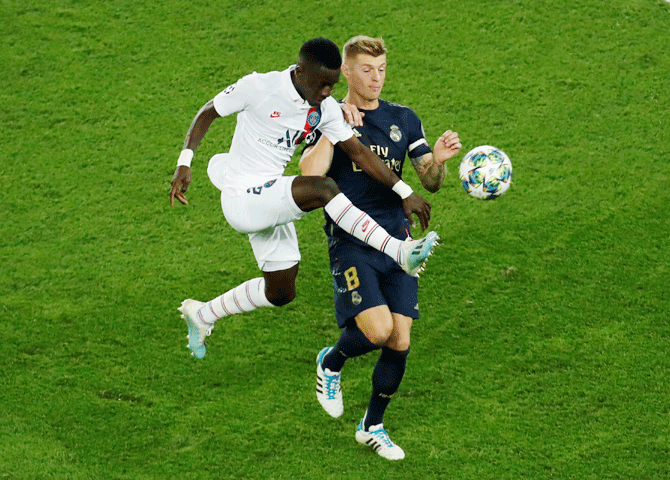Real Madrid's Toni Kroos and with Paris St Germain's Idrissa Gueye vie for possession 