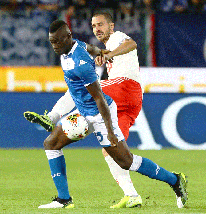 Brescia Calcio's Mario Balotelli competes for the ball with Juventus' Leonardo Bonucci